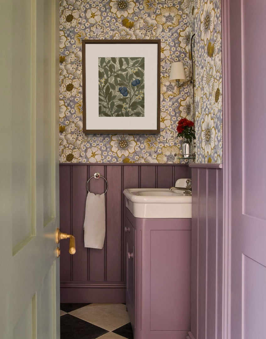 Pretty lilac colour drench bathroom with vintage floral wallpaper and vintage William Morris framed wall decor