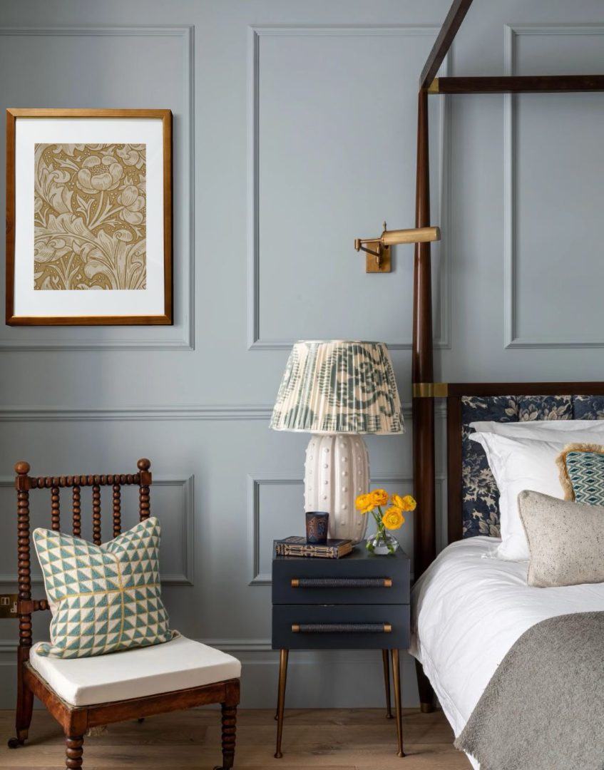 Decorative bedroom with a bed, chair, lamp, and william morris bachelors button gold wall art.