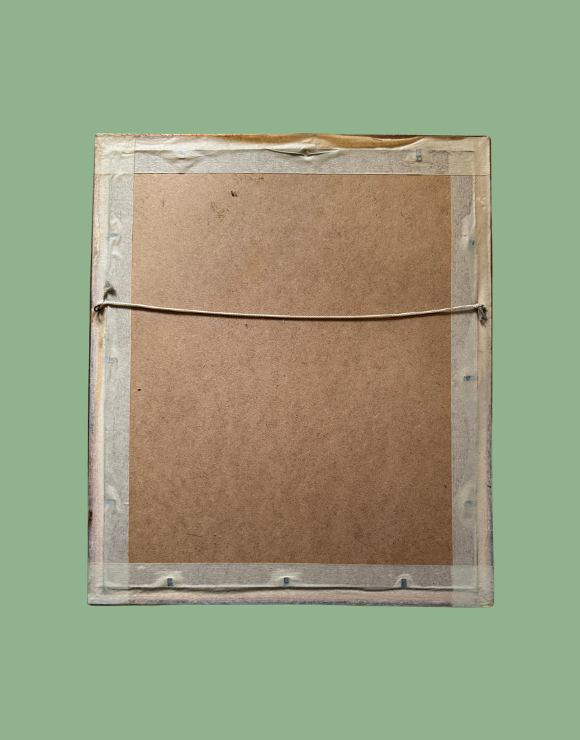 Back of a framed artwork with cardboard backing on a green background