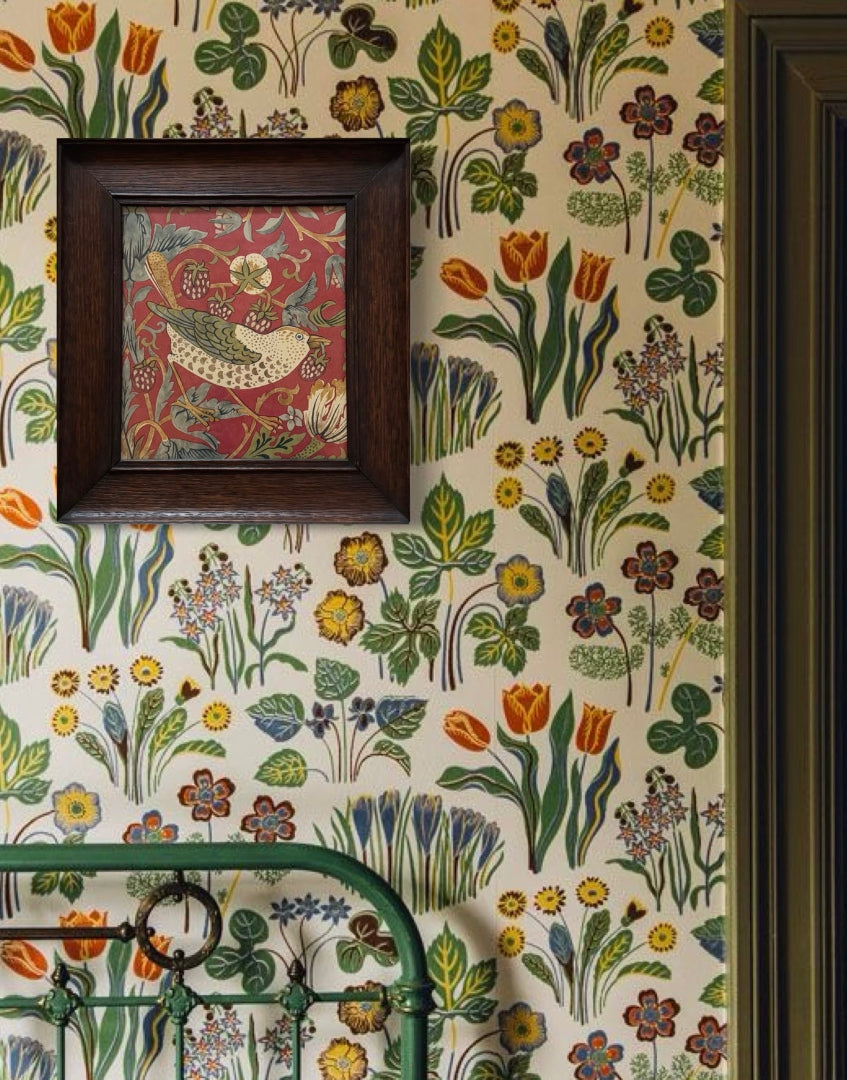 Cottage core style bedroom interior with green metal bed head and floral wallpaper with William Morris framed wall decor