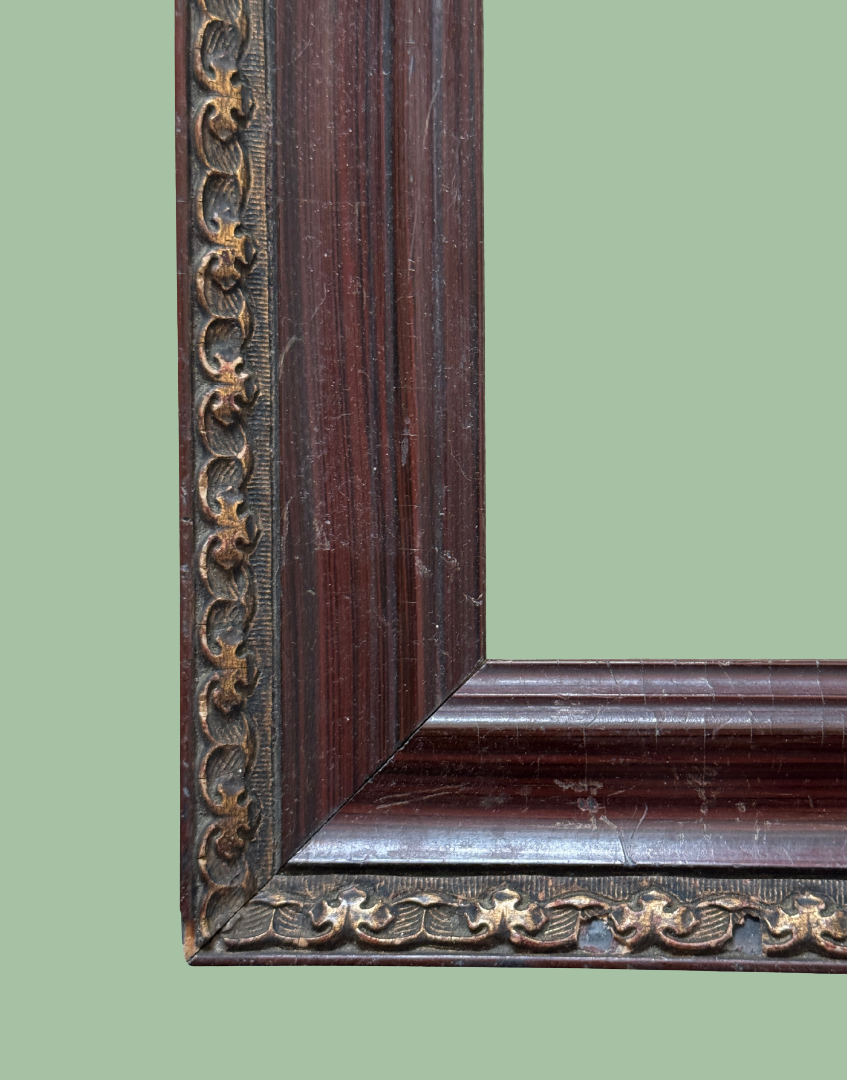 Detailed antique picture frame showing dark wood grain and ornate metal embellishment.