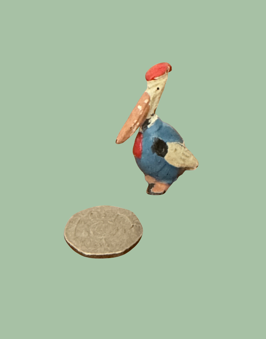 miniature cadbury cococub pelican lead figurine next to twenty pence coin to show scale