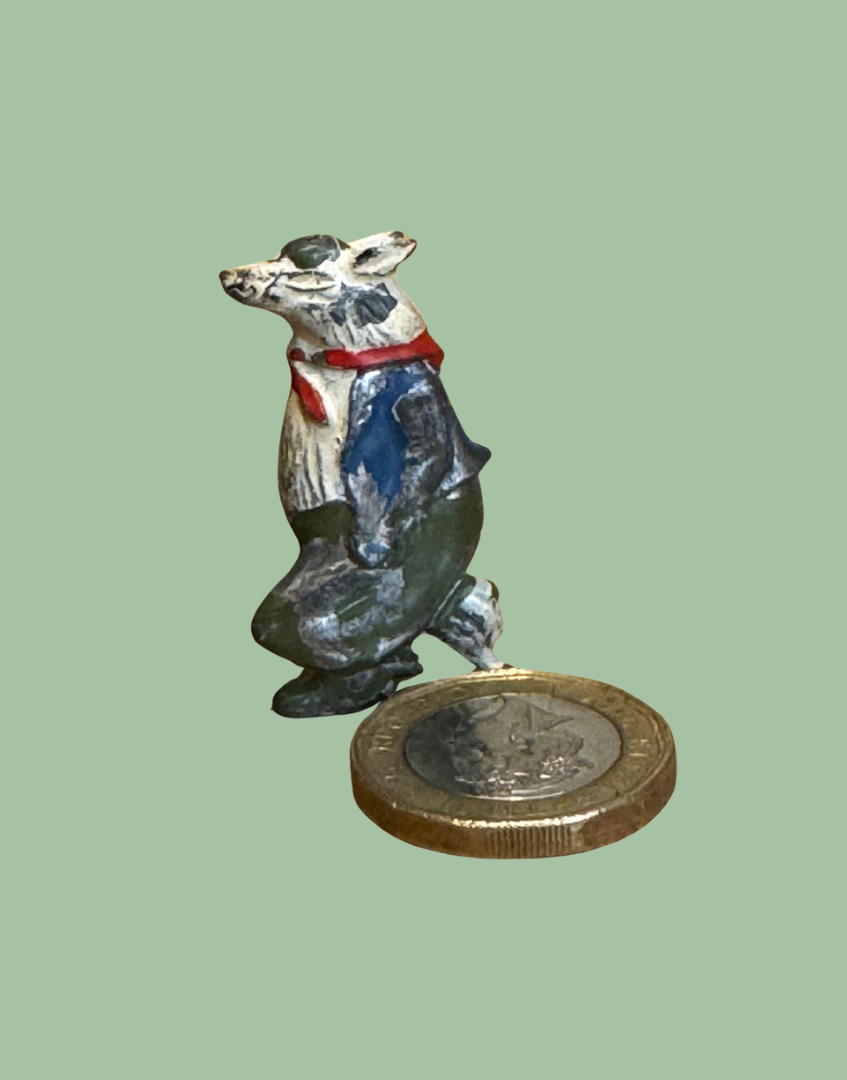 Antique miniature Britains Bill Badger lead figure next to one pound coin