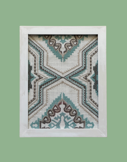 Framed geometric patterned textile on a green background