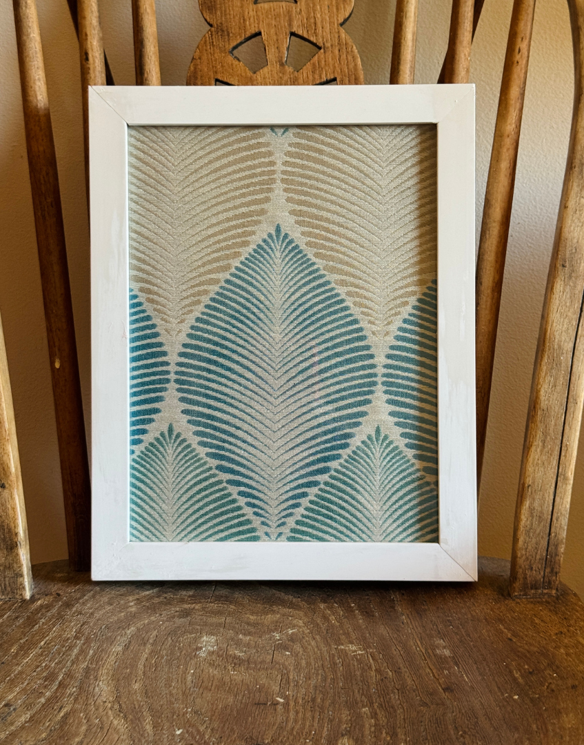Framed artwork with a geometric pattern on an antique wooden chair seat