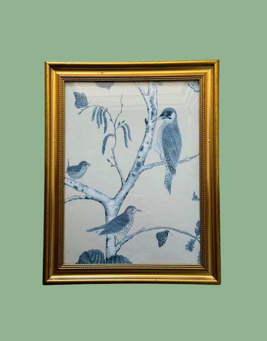 Framed artwork with blue birds on a branch against a light background