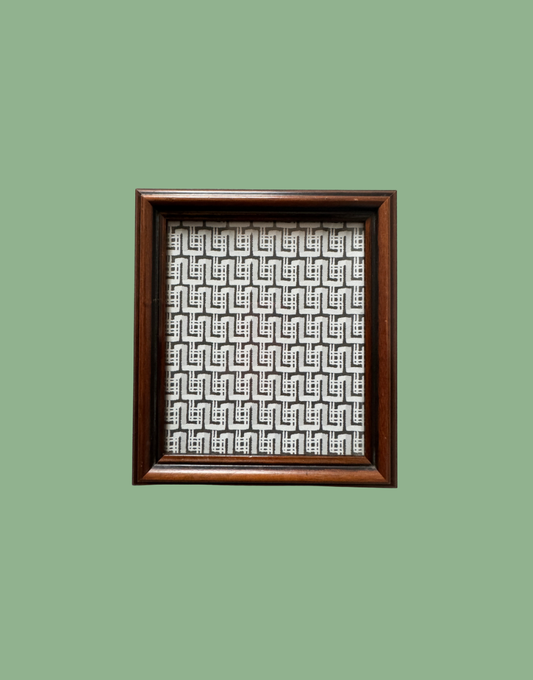 Framed artwork with geometric pattern on a green background