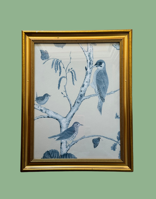 Framed artwork with blue birds on a branch against a light background