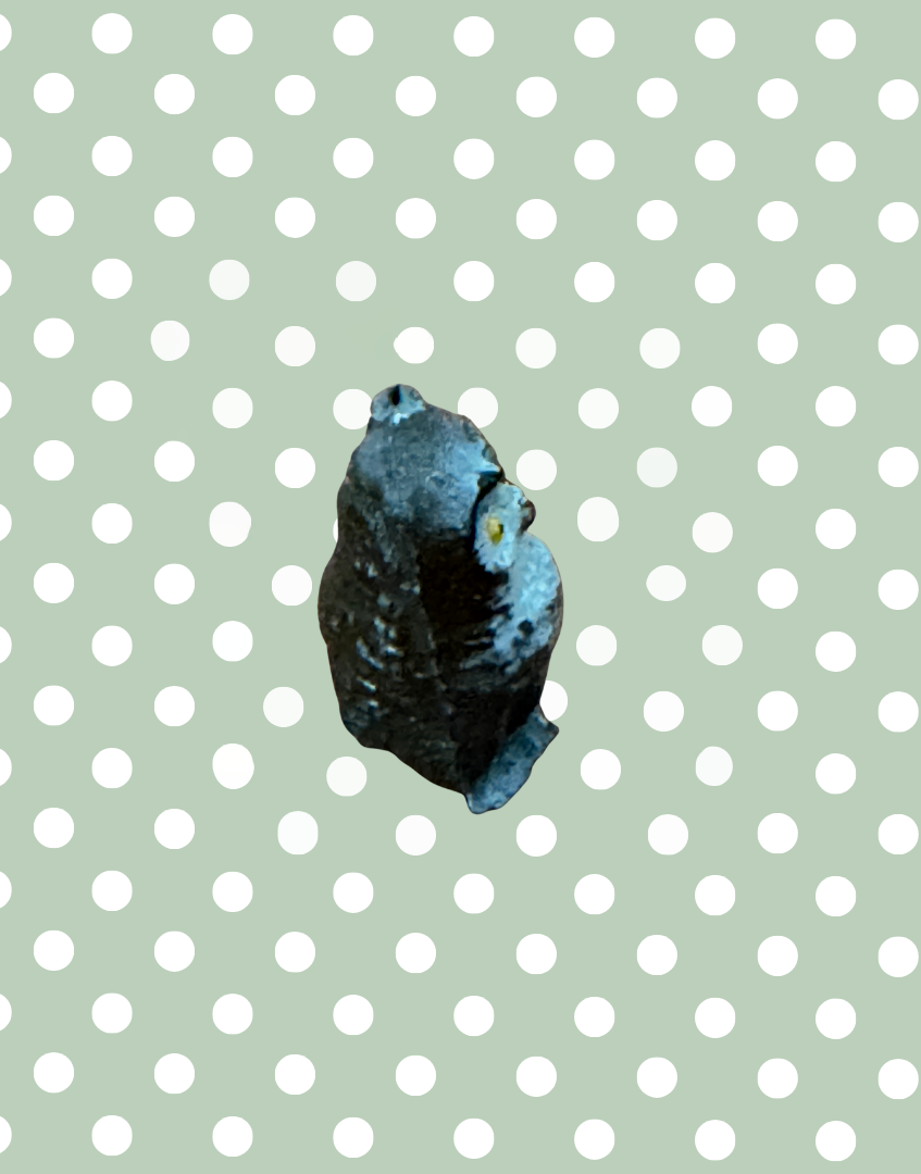 side view of antique lead figurine of an owl