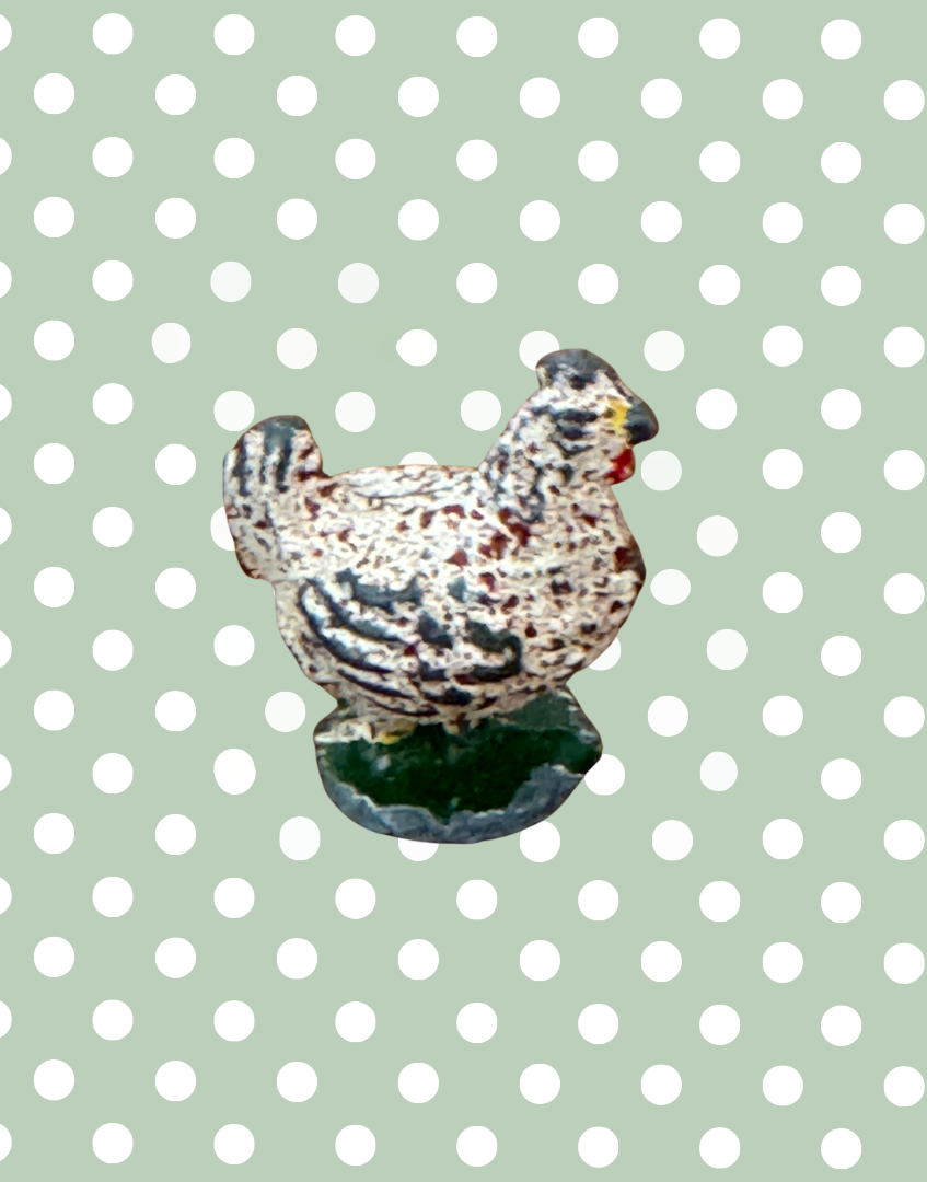 Britains lead chicken figurine on a polka dot background
