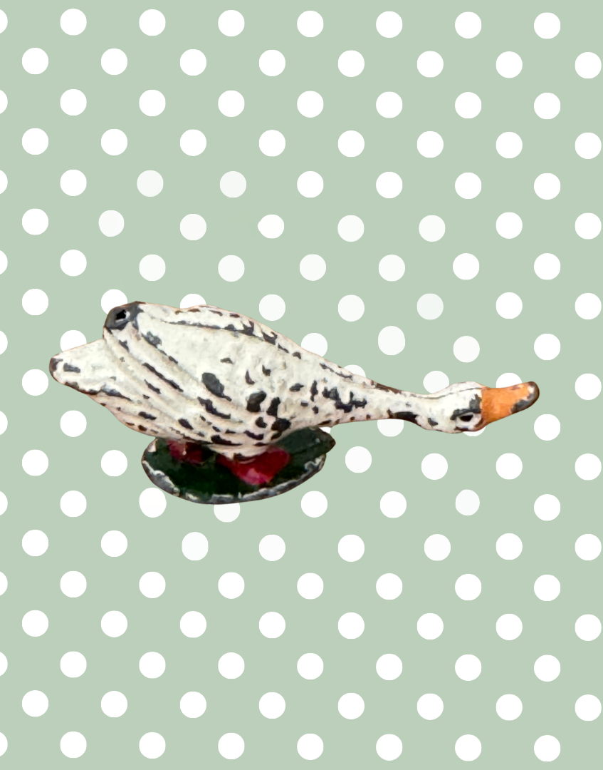 Decorative goose figurine on a polka dot background
