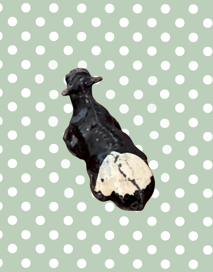 side back view of black and white calf lead figurine