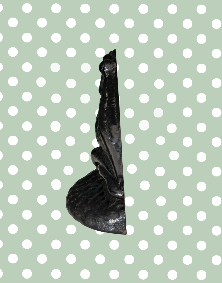 Side profile of vintage black cast iron frog doorstop with detailed features