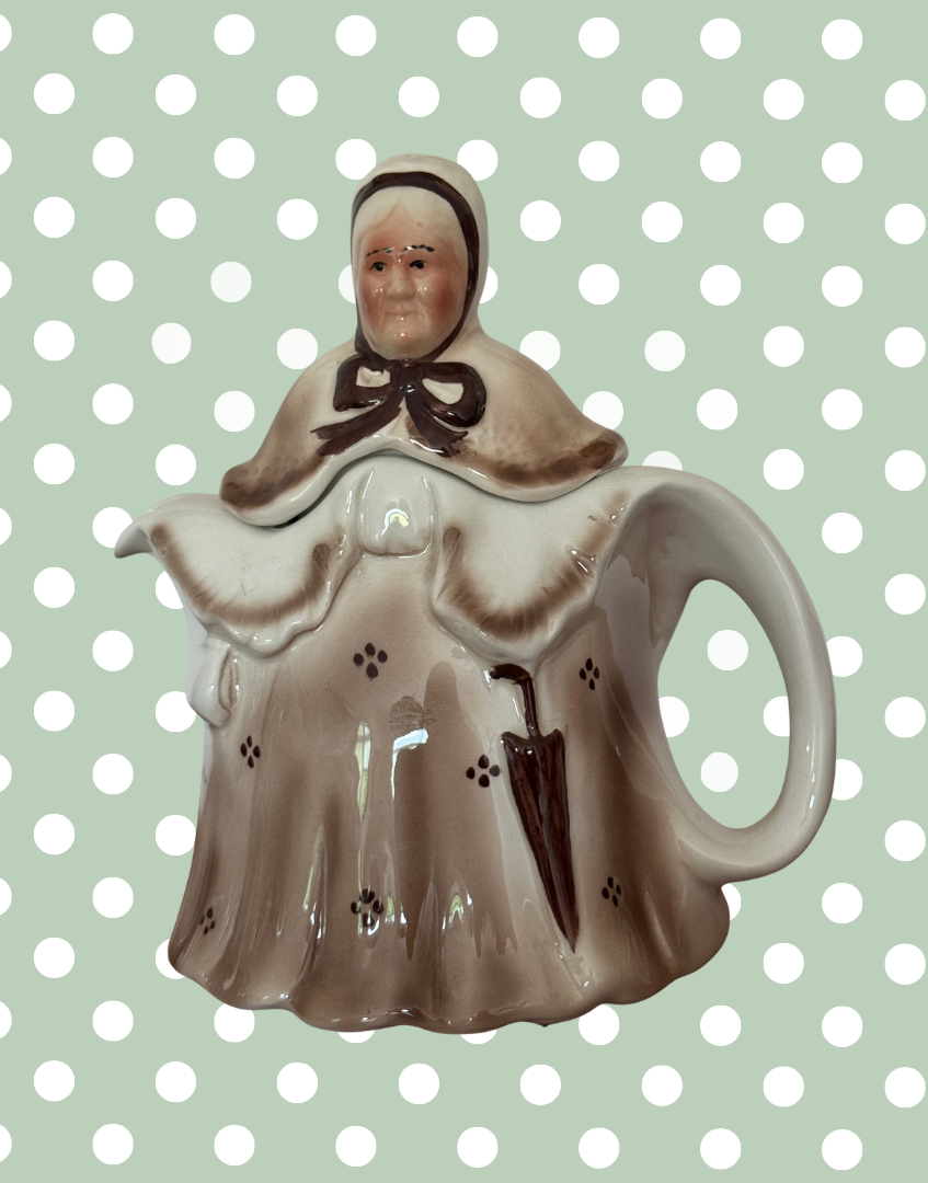 Vintage Staffordshire pottery teapot by Tony Wood featuring Little Old Lady character with umbrella and brown glaze front angle