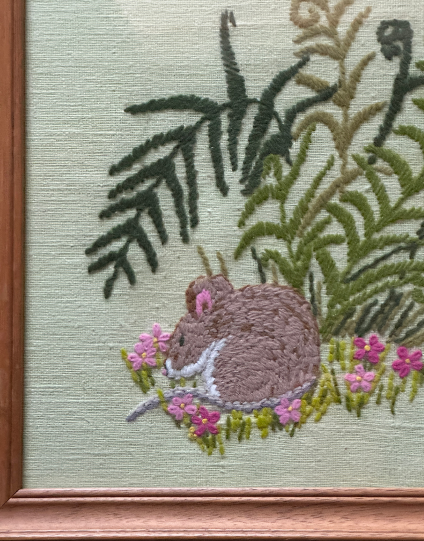 Close up of wooden frame corner with vintage wear and glass front detail on cottagecore embroidery artwork
