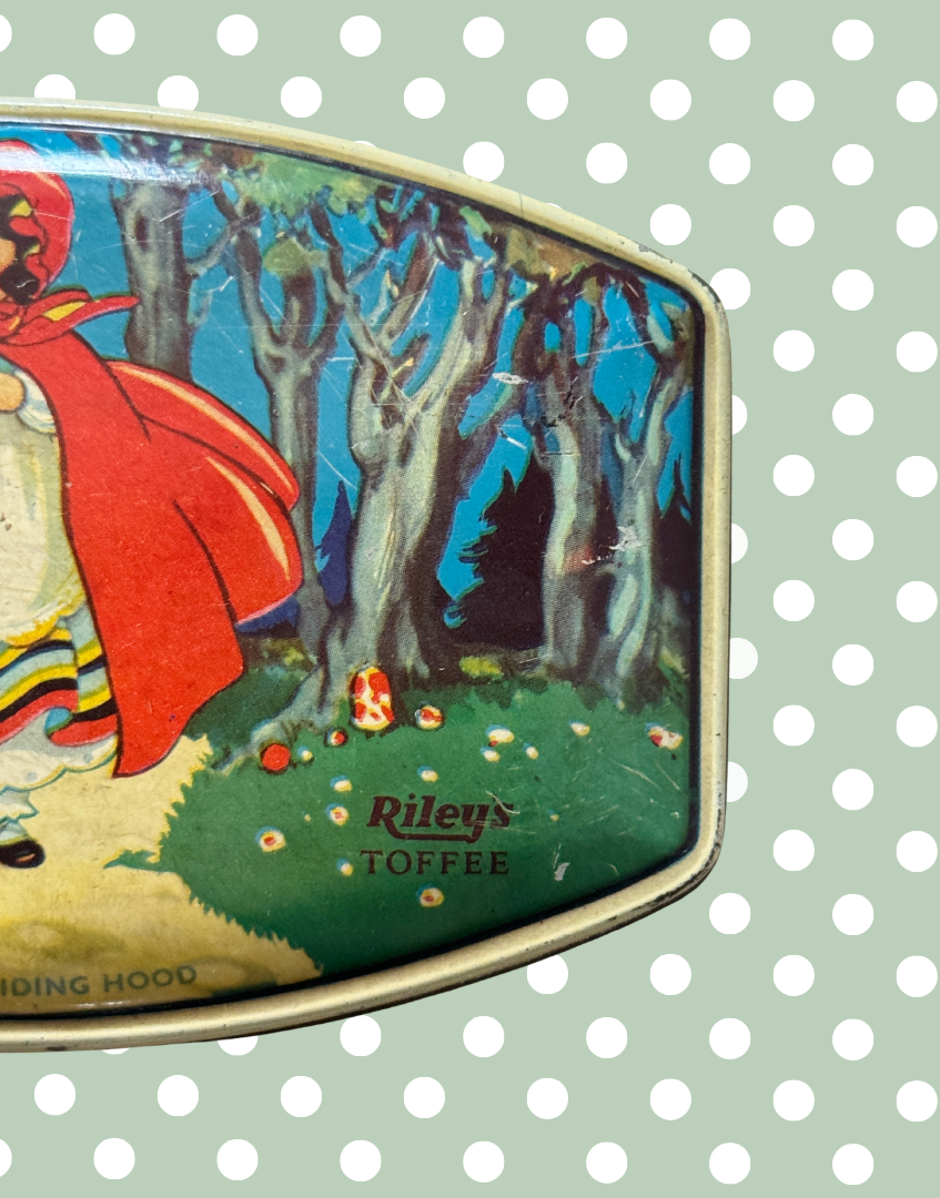 Close up right side of vintage Rileys Toffee tin showing Little Red Riding Hood artwork, woodland trees and Rileys Toffee logo detail