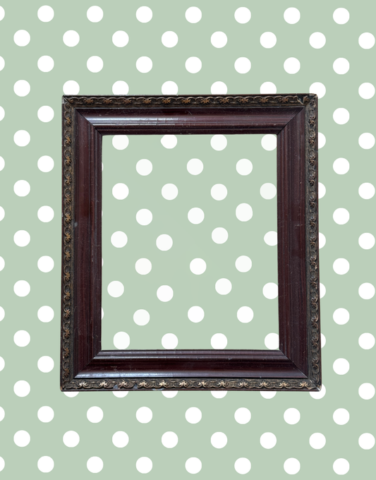 Antique decorative dark wood and metal picture frame with aged detailing and empty aperture.