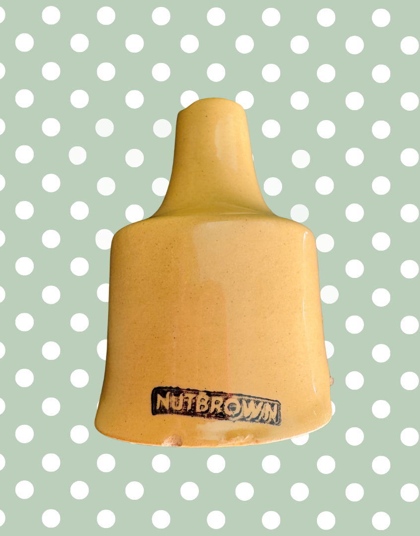 Close-up showing small chips to the base and minor manufacturing imperfection on vintage Nutbrown pie funnel with original Nutbrown maker’s mark on the base.


