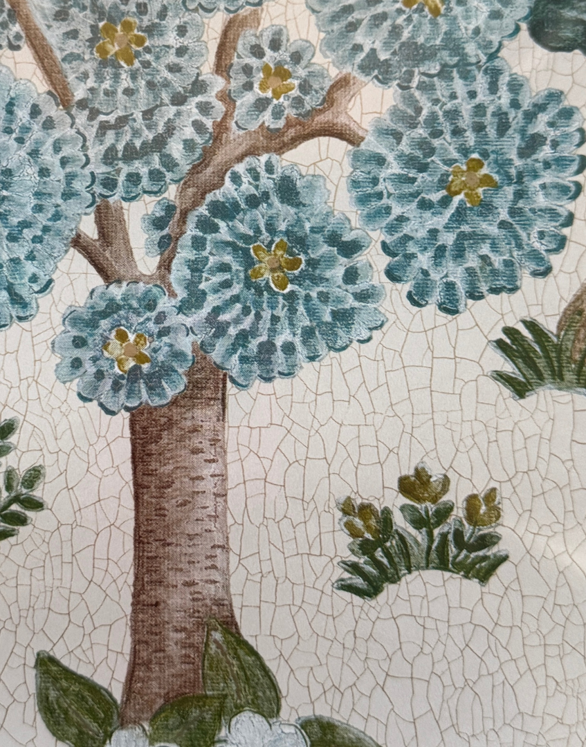 Close-up of a floral pattern with blue flowers and green leaves on a textured background.