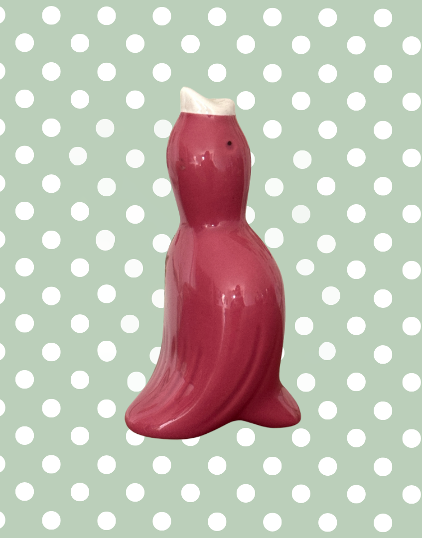 A vintage pink pottery pie funnel designed to look like a bird.