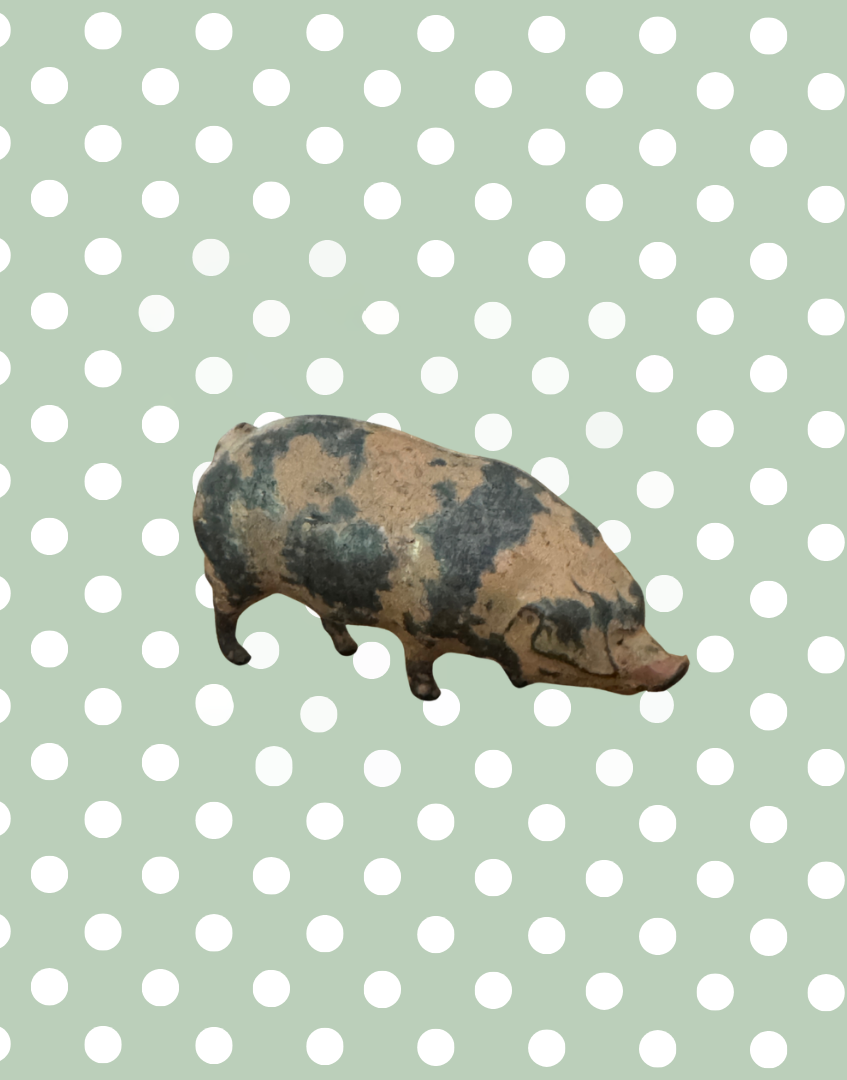 Decorative lead pig figurine on a polka dot background