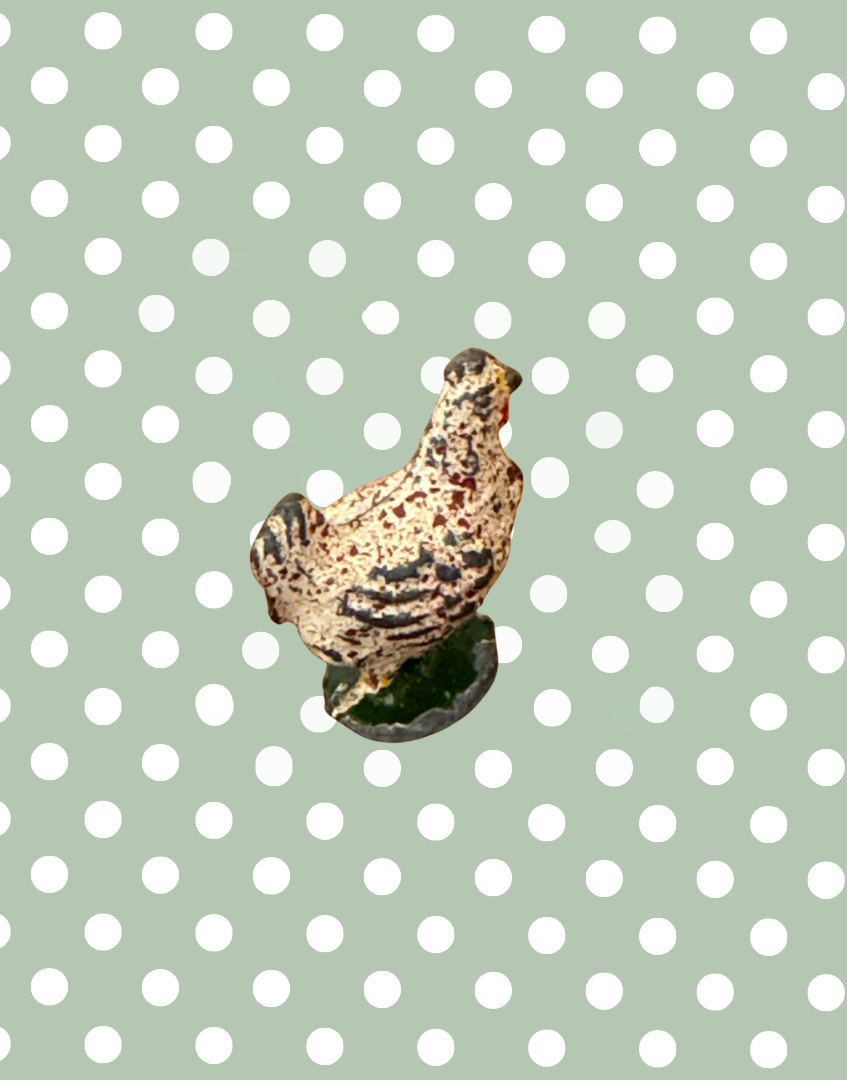 Small britains chicken lead figurine on a polka dot background
