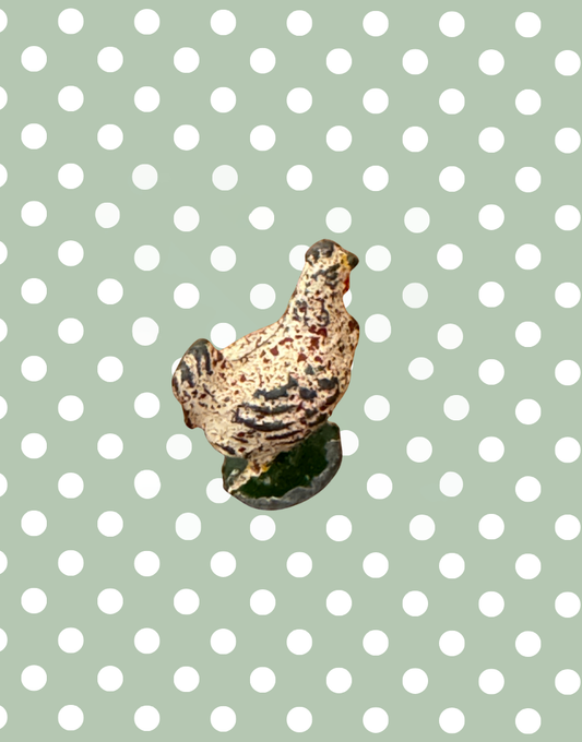 Small britains chicken lead figurine on a polka dot background