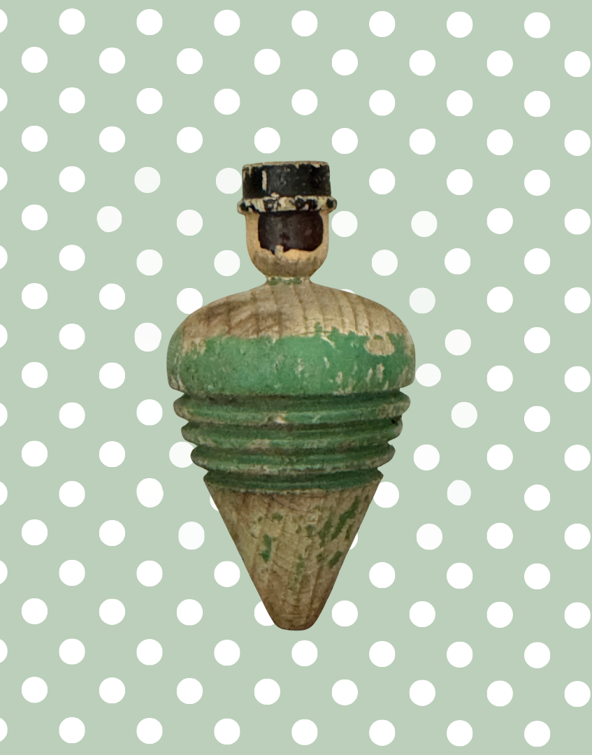Back view of antique wooden spinning top with a hand carved gentleman’s head, painted black hair and bowler hat.