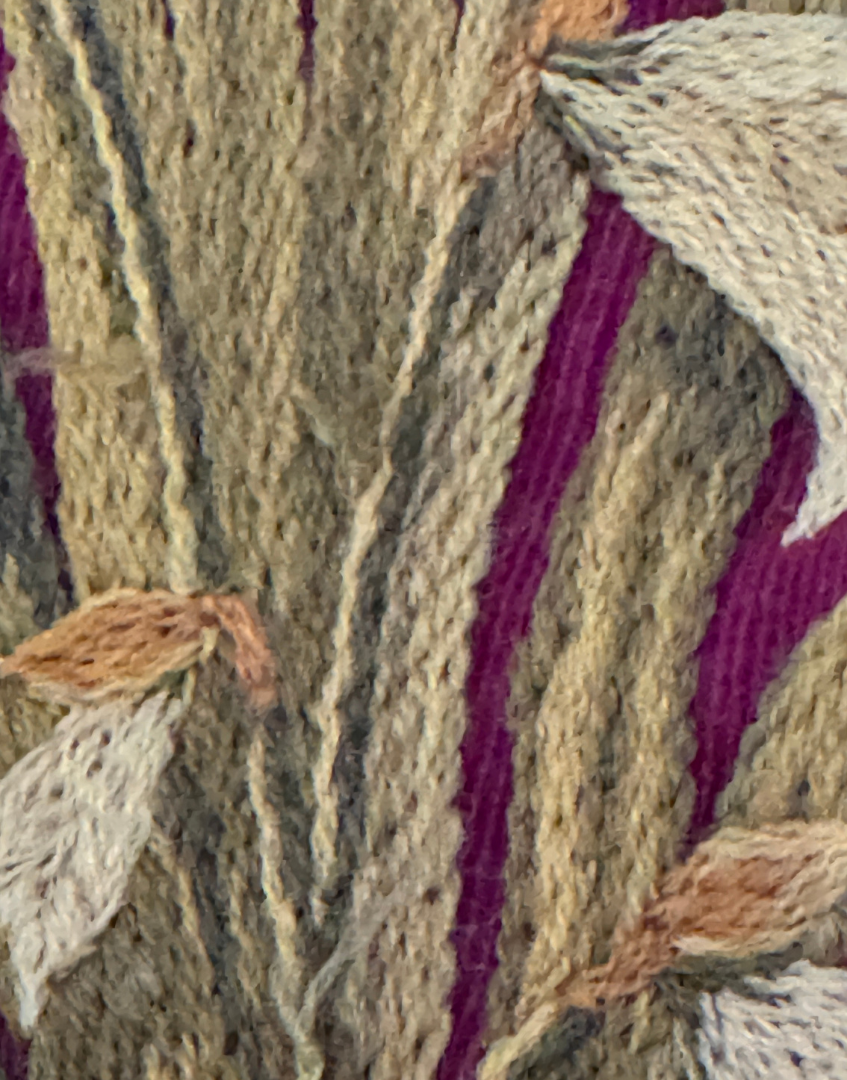 Close up of embroidered iris with raised wool stitching and rich tactile texture on the antique Arts and Crafts pelmet.