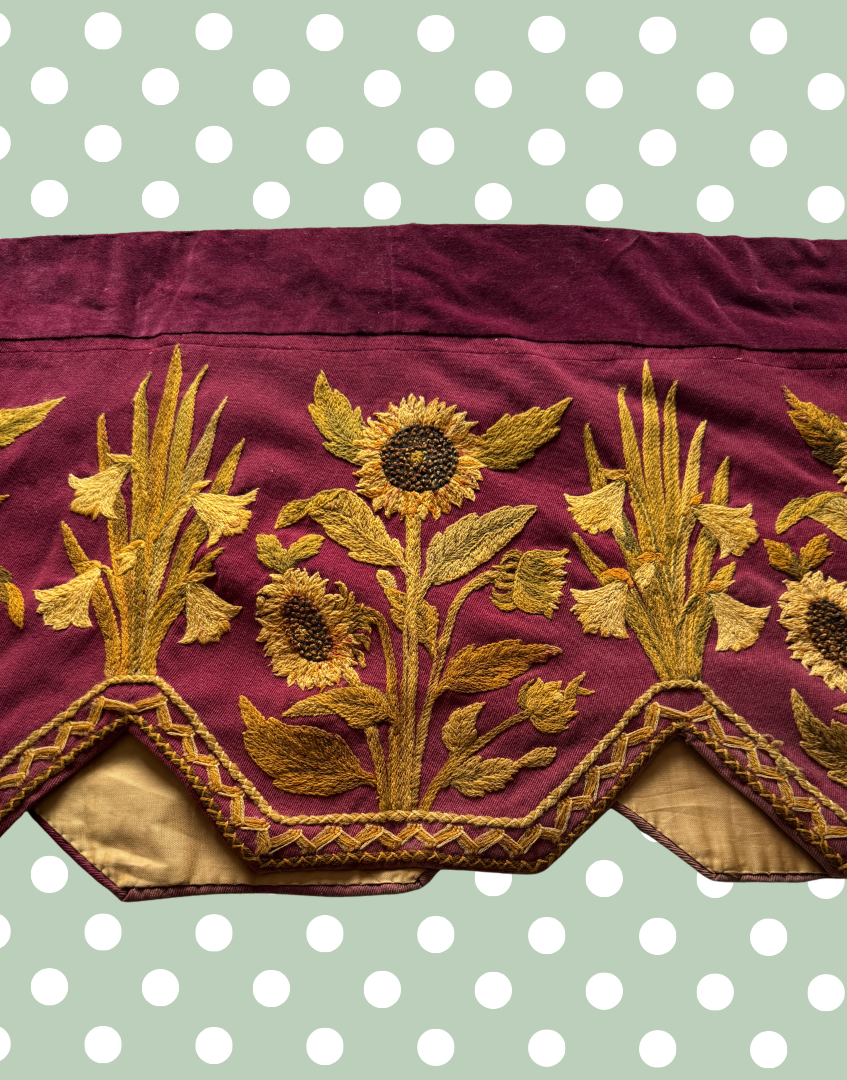 Front mid left section of the antique Arts and Crafts pelmet showing embroidered flowers, foliage and stepped lappet detail.