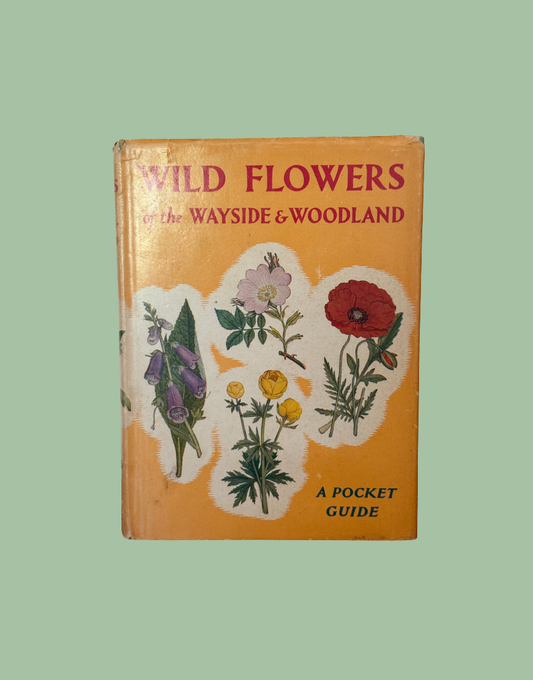 Vintage pocket guide book titled 'Wild Flowers on the Wayside & Woodland' with a yellow-orange cover, illustrated wildflowers, and the text 'A Pocket Guide'.