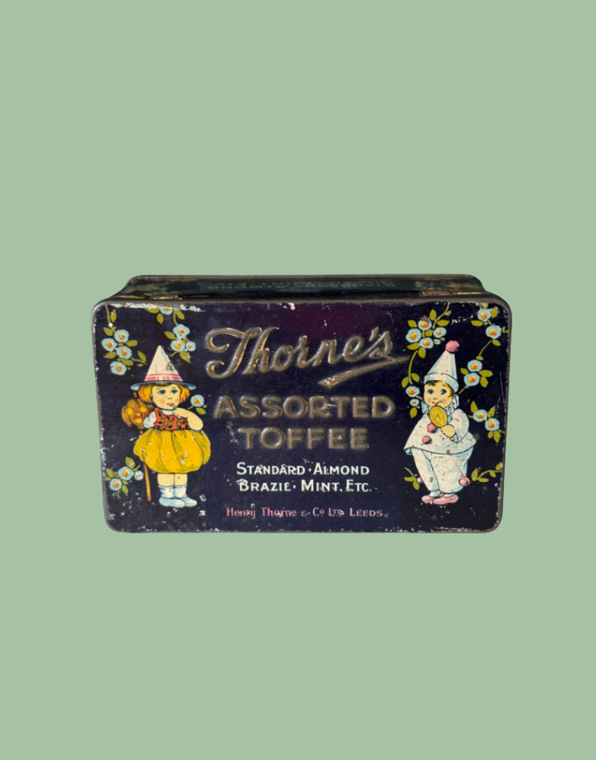 Vintage Thorne's Assorted Toffee tin box with illustrated figures and floral details on a solid sage green background.