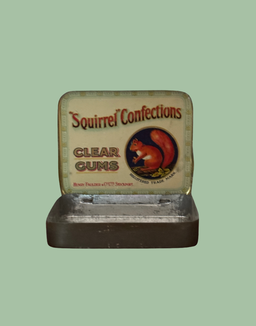 An open vintage-style metal tin of Squirrel Confections Clear Gums, showing the cream-colored label with a red squirrel illustration, set against a solid light green background.