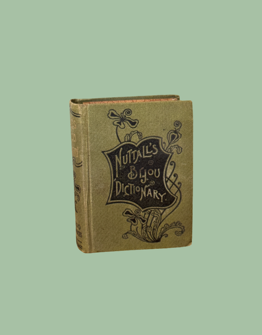 An antique hardcover dictionary titled 'Nuttall's & You Dictionary' with a tan cloth cover and black decorative lettering, shown against a solid sage green background.