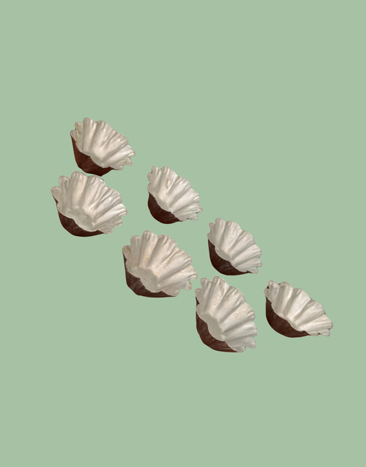 Seven vintage petit four moulds arranged in rows showing matching fluted design and aged metal character