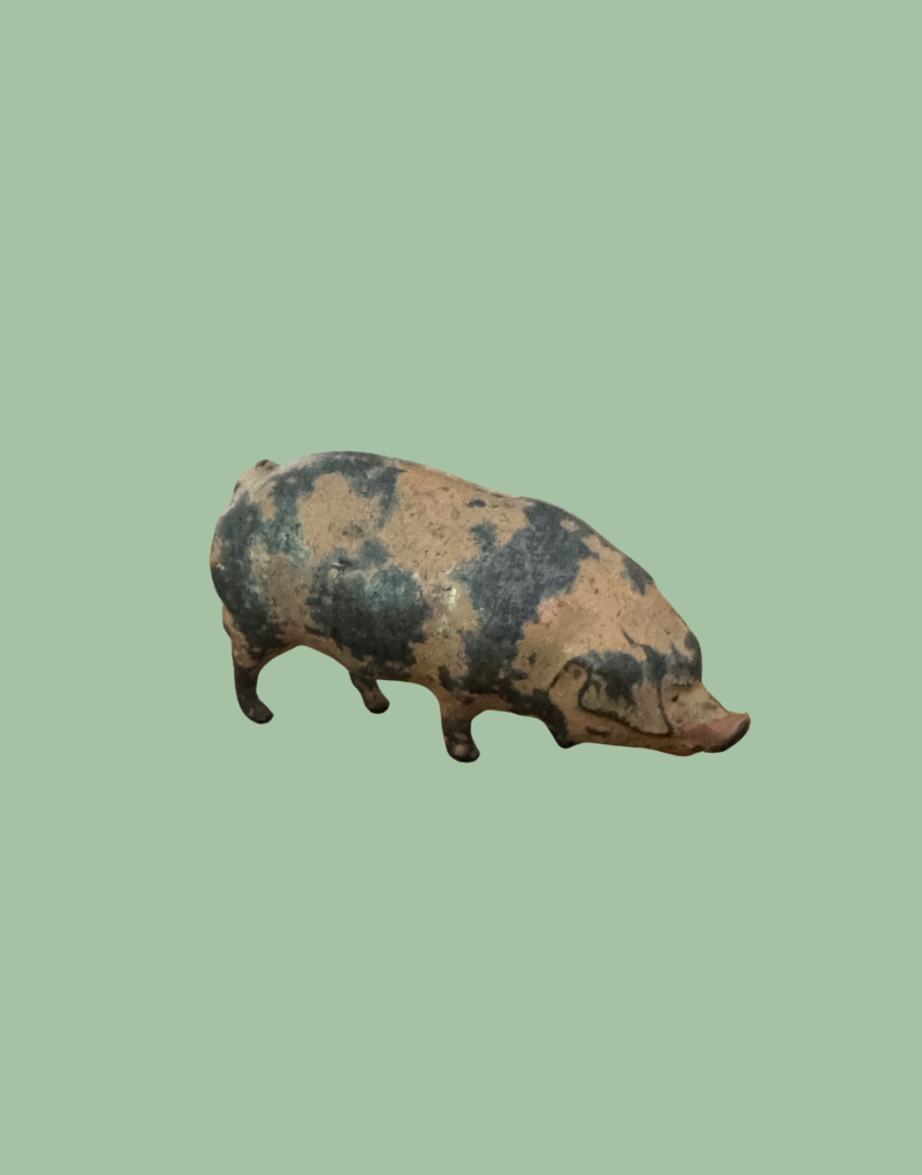 Decorative lead pig figurine on a polka dot background