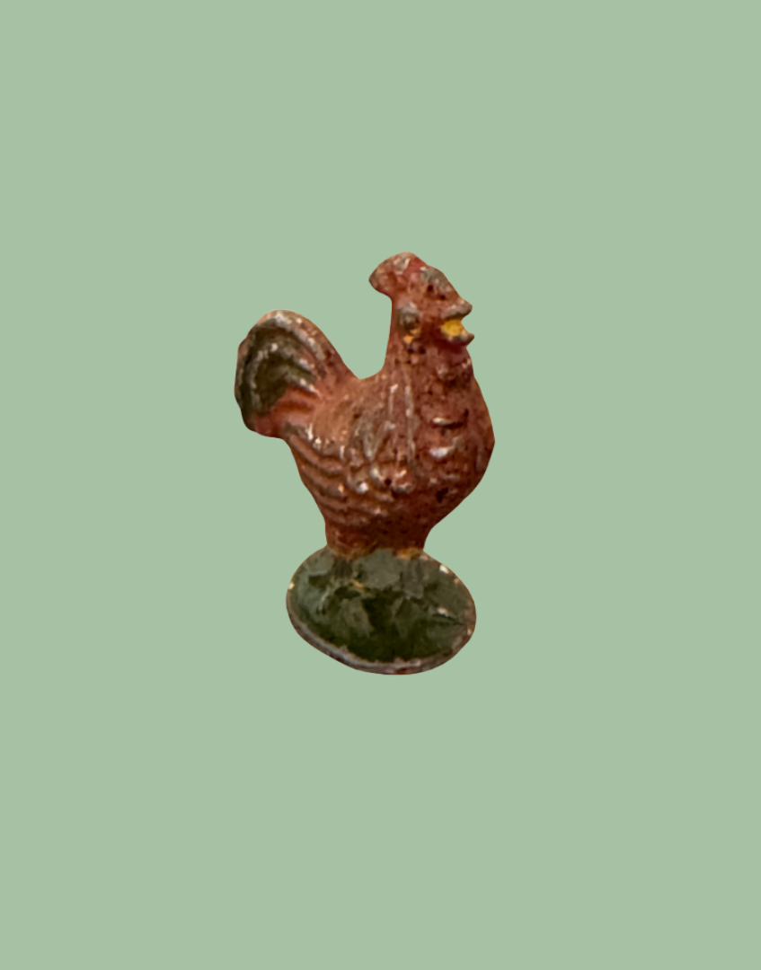 brown rooster lead figurine on green stand