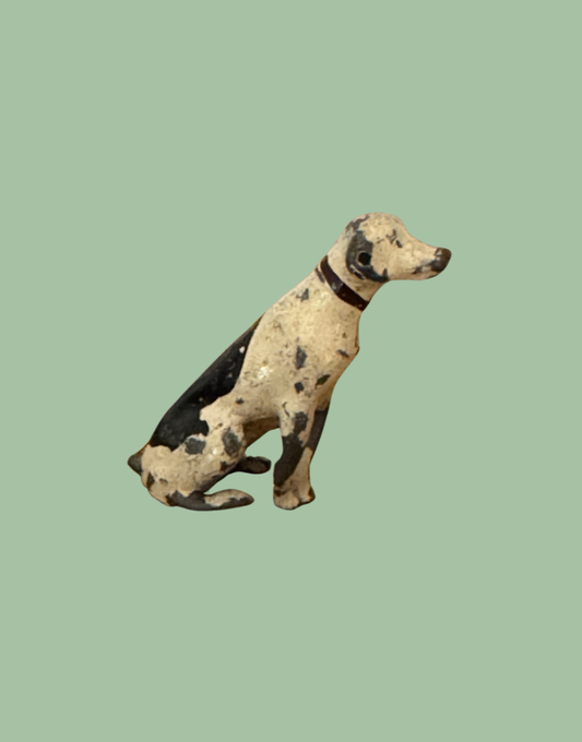 Rear side view of sitting black and white spotted Britains dog with black 