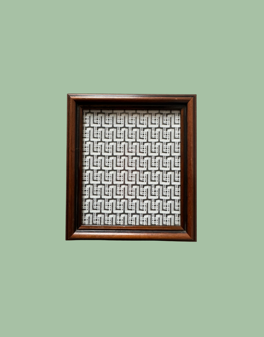 Framed artwork with geometric pattern on a green background