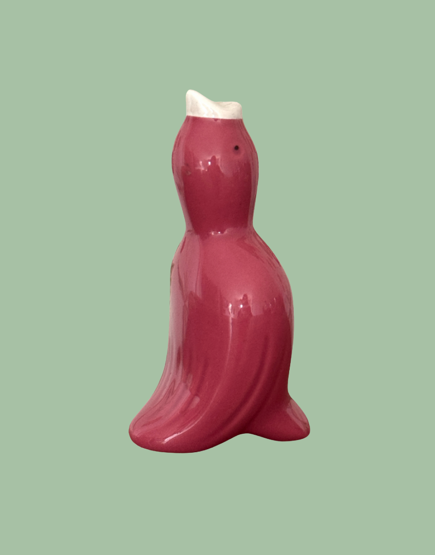 A vintage pink pottery pie funnel designed to look like a bird.