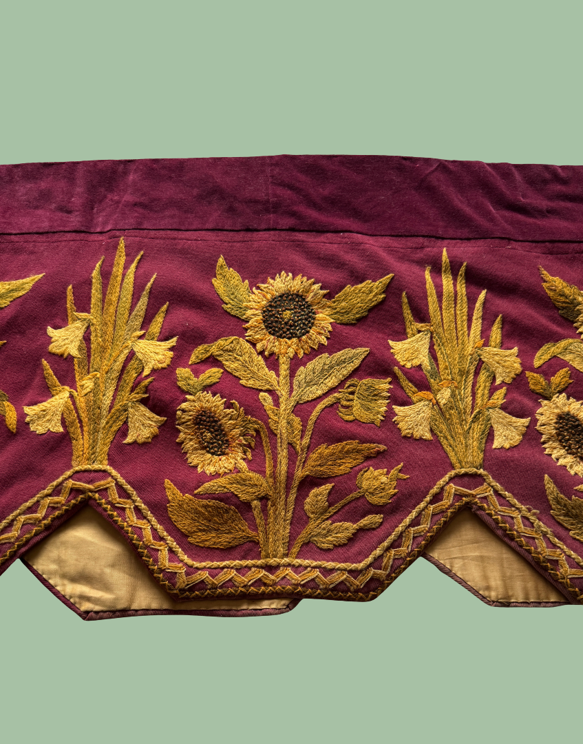 Front mid left section of the antique Arts and Crafts pelmet showing embroidered flowers, foliage and stepped lappet detail.