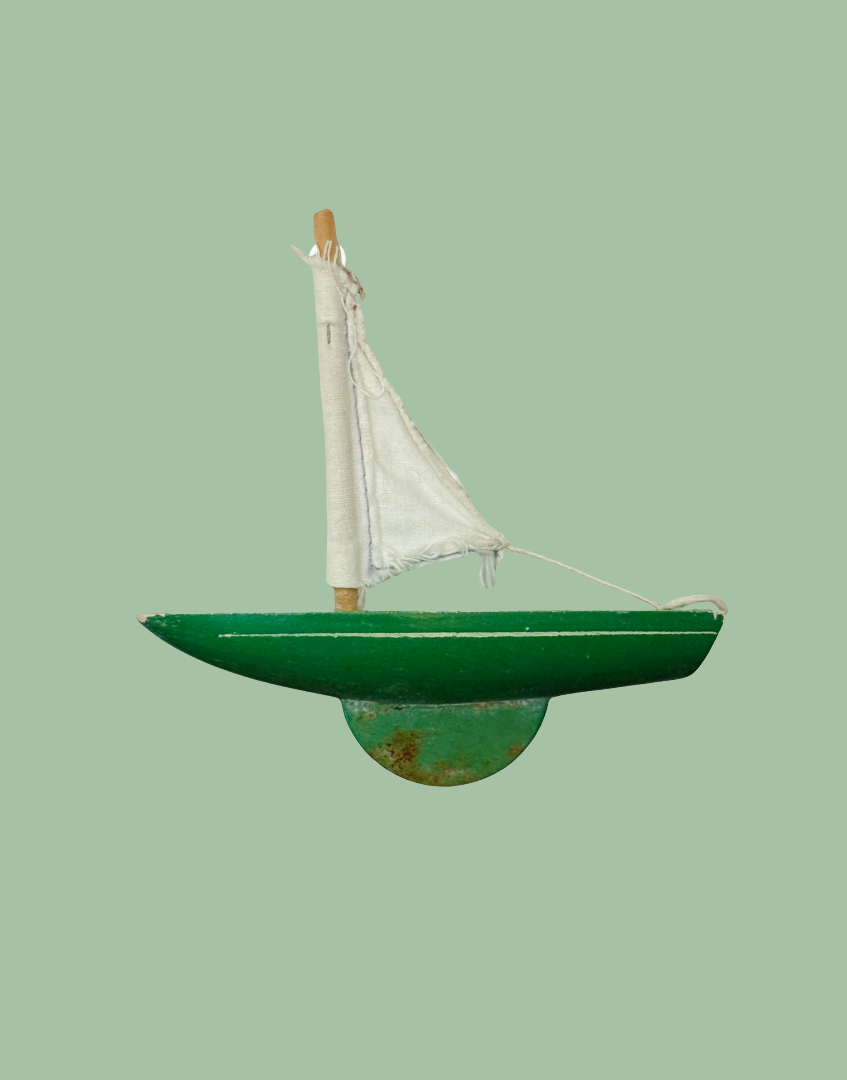 Alternate side view of the miniature green Star Yachts pond yacht with white sail and traditional wooden 