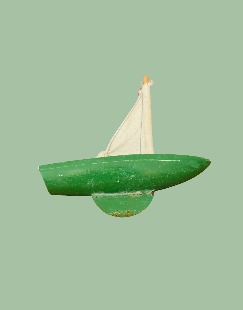 Underside side view of the vintage Star Yachts pond yacht showing the painted wooden hull and aged green keel.