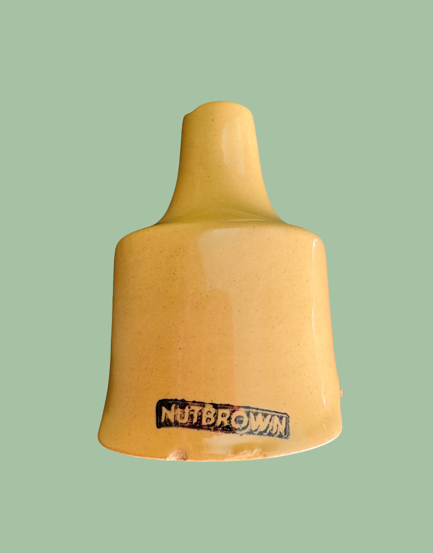 Close-up showing small chips to the base and minor manufacturing imperfection on vintage Nutbrown pie funnel with original Nutbrown maker’s mark on the base.