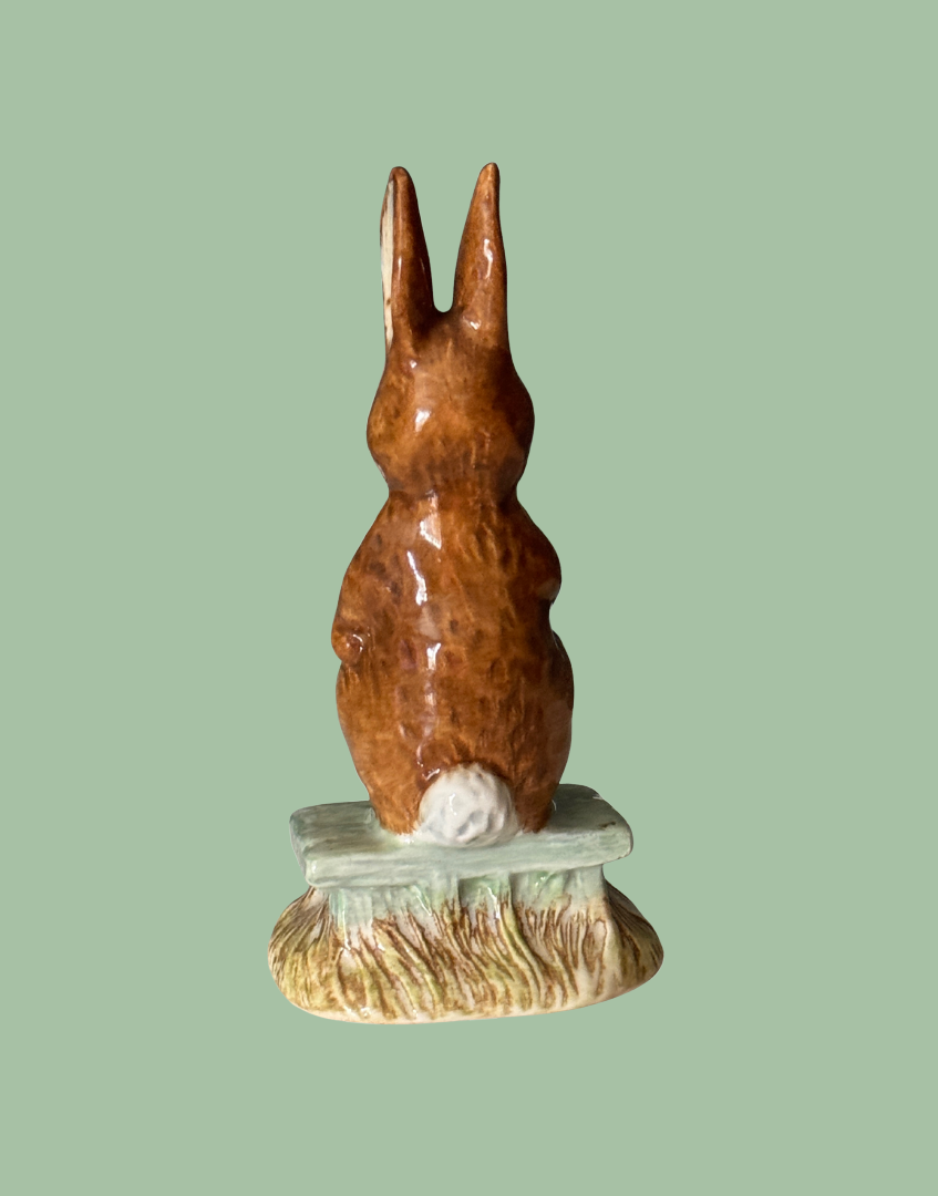 Back view of adorable brown glossy rabbit collectale with fluffy white tail