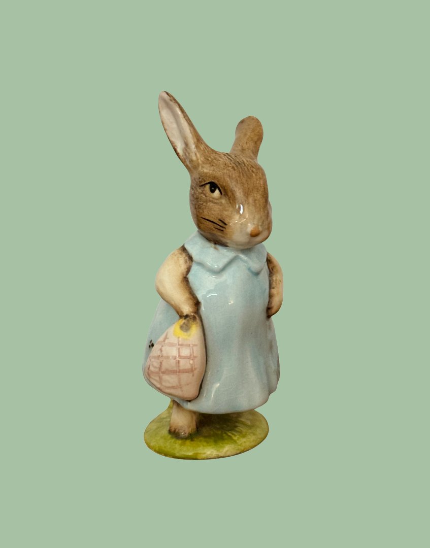 Front side view of Beswick Mrs Flopsy Bunny showing her blue clothing and small handbag.