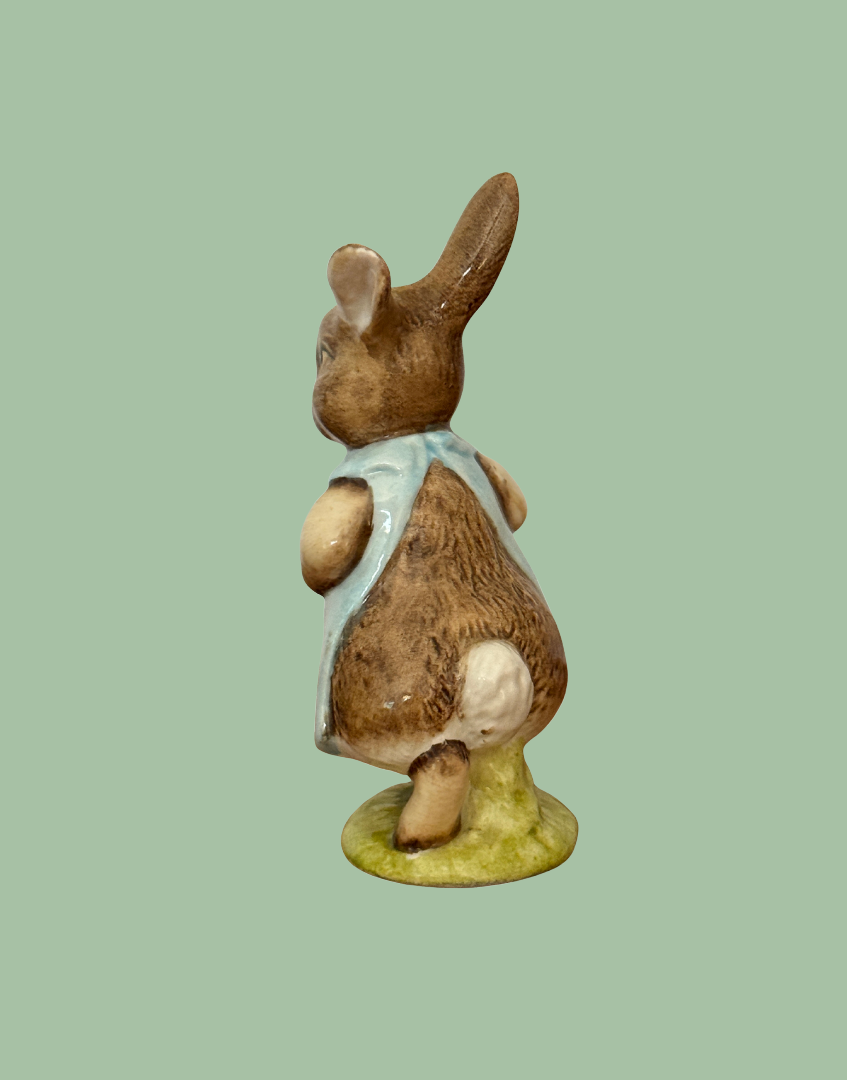 Left rear view of vintage Beswick Mrs Flopsy Bunny showing her white tail and green base.