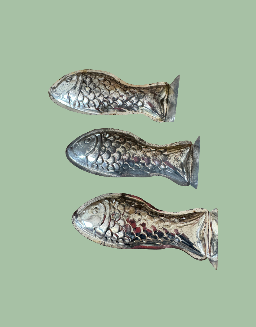 Row of three vintage tinplate fish moulds highlighting the original shape and rustic brocante character
