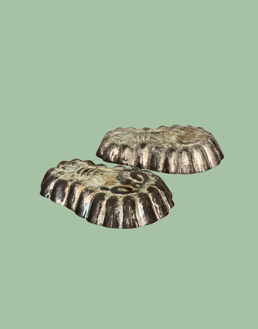 Side view of matching vintage lobster shaped tinplate mould pair showing detailed outline and decorative design