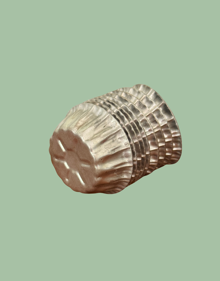 Side view of stacked vintage aluminium star moulds showing embossed star pattern on the base and original culinary design